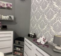 Interior of commercial spaces with white furniture, decorations, and patterned wallpaper.