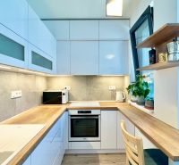 A bright kitchen with built-in appliances and wooden decor in a 2-room apartment.