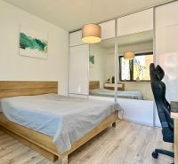 Bedroom in a 2-room apartment with a bed, wardrobe, and desk.