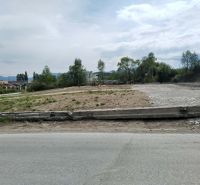Commercial plots in Martin with an asphalt road and greenery in the background.