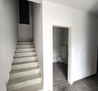 Interior of a family house with marble stairs and a bathroom with a black floor.