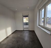 A bright room with windows and a balcony in a family house, floor with a dark decor.