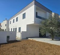 A family house in Vrsi with a white facade and an adjacent plot.