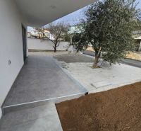 A terrace at a family house in Vrsi with paving and an olive tree.