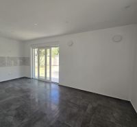 Living room in a family house with dark tiles and sliding doors to the terrace.