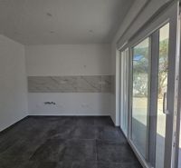 Interior of a family house with tiles, white walls, and large glass doors.