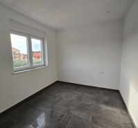 Interior of a room in a family house with white walls and a dark floor.