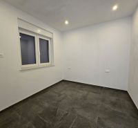 A room with white walls and a dark floor in a family house.