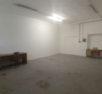 Empty room with tables and chairs in warehouse and hall spaces.
