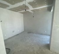 Interior in a 3-room apartment with a concrete floor and unplastered walls.