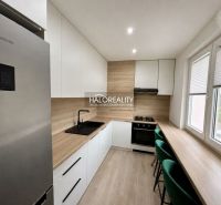 A kitchen in a 2-room apartment with a wooden decor floor and modern equipment.