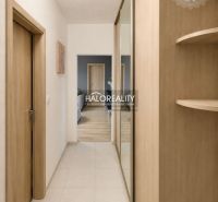 A hallway with a mirrored wardrobe in a 2-room apartment with a wooden decor.