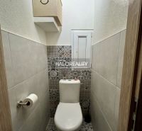 Bathroom with toilet in a 2-room apartment, light walls, patterned tiles.