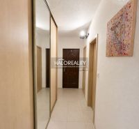 A hallway in a 2-room apartment with tiles, a built-in wardrobe, and a picture on the wall.