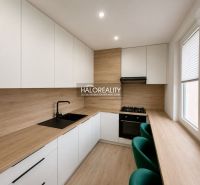 A kitchen in a 2-room apartment with a wooden decor floor and furniture.