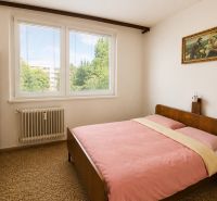 A bedroom with a double bed, older furniture, and a large window in a 3-room apartment.