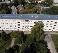 Apartment building on Robotnícka Street in Senica with surrounding greenery and trees.
