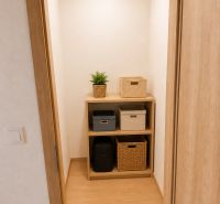 Storage space in a 3-room apartment with shelves and boxes, floor with wood decor.