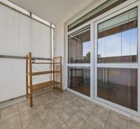 Balcony of a 3-room apartment with tiles and a wooden shelf.
