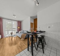 Living room in a three-room apartment with a wooden decor floor and a dining area.