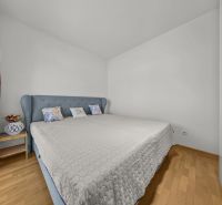 Bedroom with a large bed and floral decoration in a 3-room apartment.