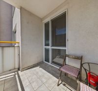 A balcony with a tiled floor and folding chairs in a 3-room apartment.