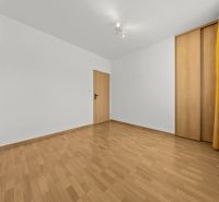 A room with a wooden decor floor, a built-in wardrobe, and yellow curtains in a 3-room apartment.