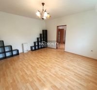 A room in a 3-room apartment with a wooden decor floor and shelves.