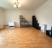 Living room with a shelving system, sofa, and wooden decor flooring in a 3-room apartment.