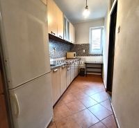 A kitchen in a 3-room apartment with tiles and a light cabinet.
