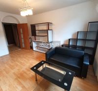 A kitchen in a 3-room apartment with tiles and light furniture.