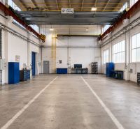 A spacious hall with work desks and tools, a floor with a wooden decor.