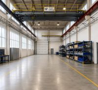 Interior of a warehouse with shelves and industrial equipment, bright lighting and concrete floor.