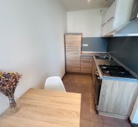 A kitchen in a 3-room apartment with a kitchen unit and a dining table with a wooden decor.