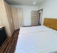 Bedroom with a double bed and a wardrobe in a 3-room apartment with a wooden decor floor.