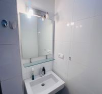 Bathroom sink with mirror in a 3-room apartment, simple and clean design.