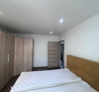 Bedroom with a double bed, built-in wardrobe, and wooden decor flooring in a 3-room apartment.