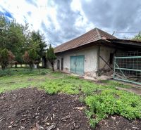 A family house in Čifáre with a large yard and an older shelter, surrounded by greenery.