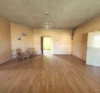 Interior of a family house with a wooden decor floor and simple seating.
