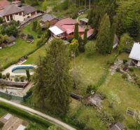 Cottages with gardens and a swimming pool in Nižný Klátov surrounded by greenery and trees.