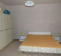 Bedroom in a family house with a double bed, nightstands, and a wardrobe.
