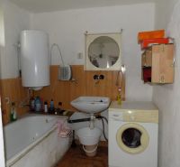 Bathroom in a family house with a bathtub, sink, and washing machine.