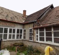 The exterior of a family house in Gbelce with a distinctive old roofing design.