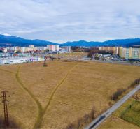 Panorama of development plots in Martin with a view of apartment buildings and mountains.