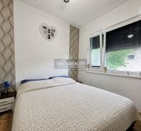 Bedroom with a bed and a decorative wall in a family house.