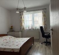 Bedroom with a bed, office chair, and dresser in a family house.