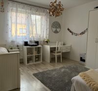 A bright room in a family house with white furniture, a desk, and decorations.