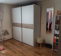 Interior of a family house with a white wardrobe and a wooden decor floor.