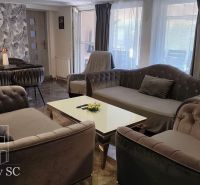 Living room in a family house with comfortable sofas, a dining table, and decorative curtains.