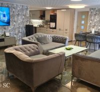 Living room in a family house with comfortable sofas, a TV, and stylish wall decor.